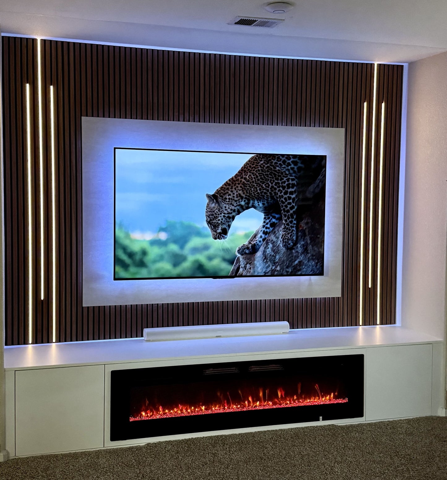 Walnut cabinetry with bespoke TV wall